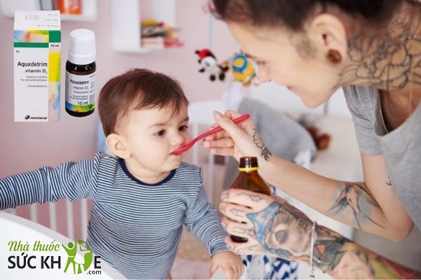 Nhỏ Aquadetrim Vitamin D3 vào thìa cho bé uống